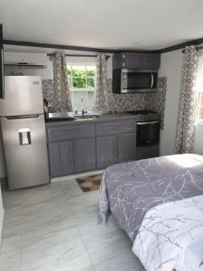 a kitchen with a bed and a refrigerator and a sink at Devachan Apartments in Bridgetown