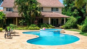 a swimming pool in front of a house at Villas Del Jardin 7 in Juan Dolio