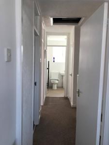 a hallway of a bathroom with a toilet in it at Diana House - Great location in Coventry