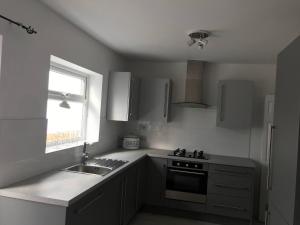 a kitchen with a sink and a stove and a window at Diana House - Great location in Coventry