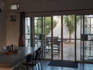 a room with a large glass door with a table and chairs at Villa JAJA Piscine-Climatisation in Poponguine