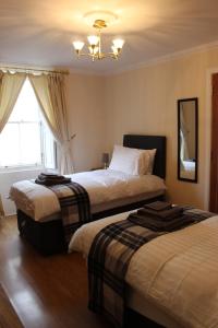 een hotelkamer met 2 bedden en een raam bij Number One in Haddington