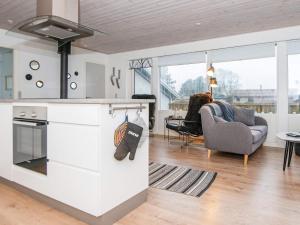 uma cozinha com fogão forno superior ao lado de uma sala de estar em Three-Bedroom Holiday home in Sydals 2 em Høruphav