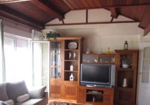 a living room with a tv and a couch at Ático, Islantilla in Islantilla