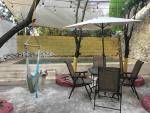 Casa Lool Beh في ميريدا: فناء مع طاولة وكراسي ومظلة