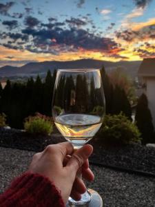 a person holding a glass of white wine at Adela's Bed and Breakfast in West Kelowna