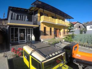 a yellow truck parked in front of a house at Homestay Lereng Bromo in Bromo