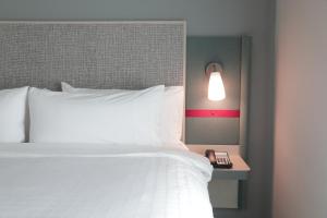 um quarto com uma cama, um candeeiro e um telefone em avid hotel - Fresnillo, an IHG Hotel em Fresnillo de González Echeverría