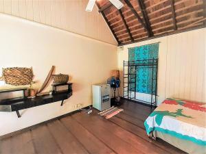 um quarto com uma cama, um frigorífico e uma janela em MOOREA - Local Spirit Iti 2 em Hauru