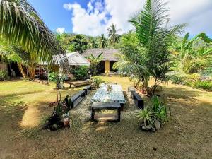 a picnic table in front of a house with palm trees at MOOREA - Local Spirit Iti 2 in Hauru