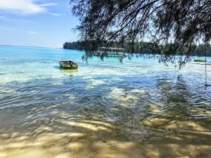 a boat in the water next to a beach at MOOREA - Local Spirit Iti 2 in Hauru +4 photos