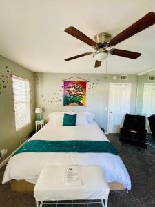 a bedroom with a large bed with a ceiling fan at Pacific Beach Butterfly Suite in San Diego