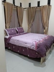 a bedroom with a purple bed with curtains at Toraja Lodge Hotel in Rantepao