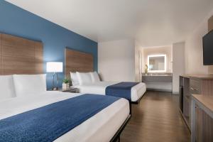 um quarto de hotel com duas camas e uma televisão em Torch Lite Inn at the Beach Boardwalk em Santa Cruz