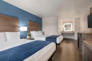 a hotel room with two beds and a television at Torch Lite Inn at the Beach Boardwalk in Santa Cruz