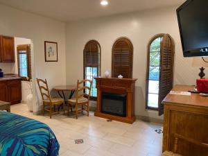 1 dormitorio con cama y mesa con chimenea en Villa Rosa Inn, en Santa Bárbara
