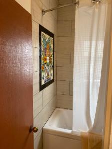 y baño con bañera y cortina de ducha. en Villa Rosa Inn en Santa Bárbara