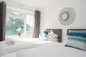 a bedroom with two beds and a window at Brynglas Newport flat sleeps 8 - Mycityhaven in Newport