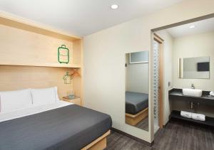 a bedroom with a bed and a sink and a mirror at Hotel MX zócalo CDMX, Trademark Collection by Wyndham in Mexico City +51 photos