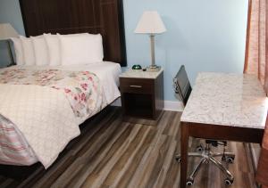 Habitación de hotel con cama y escritorio en Dolphin Cove Motel, en Pismo Beach