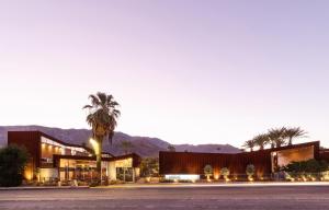 a building with a palm tree in front of a street at ARRIVE Palm Springs - Adults Only in Palm Springs