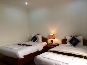 Postel nebo postele na pokoji v ubytování Emerald BB Battambang Hotel