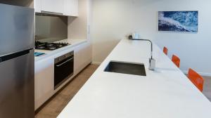 a kitchen with a white counter top with a sink at Melbourne City Apartments - Teri in Melbourne +150 photos
