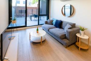 a living room with a couch and a table at Melbourne City Apartments - Teri in Melbourne