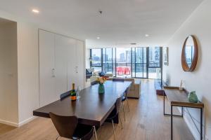 comedor y sala de estar con mesa grande en Melbourne City Apartments - Teri en Melbourne