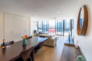 uma sala de estar com uma mesa e um sofá em Melbourne City Apartments - Teri em Melbourne