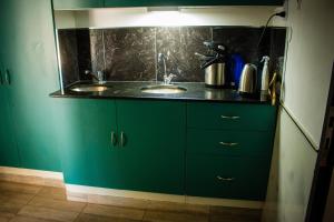 a green kitchen with two sinks and a counter at WISZ-V in Belén