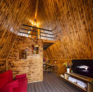 a living room with a red couch and wooden walls at S'Bungalow Bến Tre in Ben Tre