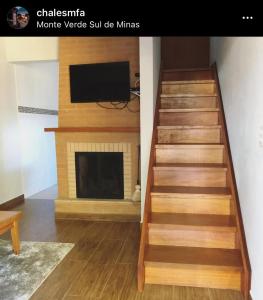 eine Treppe im Wohnzimmer mit Kamin in der Unterkunft Chales Mãe e Filho in Monte Verde