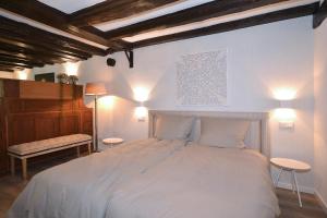 ein Schlafzimmer mit einem großen weißen Bett mit zwei Tischen in der Unterkunft Villa Delange in Landau in der Pfalz