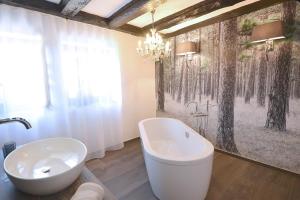 ein Badezimmer mit einer großen Badewanne und einem Waschbecken in der Unterkunft Villa Delange in Landau in der Pfalz