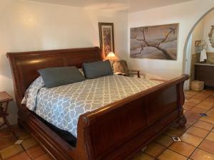 um quarto com uma grande cama de madeira com almofadas azuis em Chantico Inn em Ojai