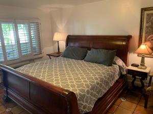 a bedroom with a large wooden bed with blue pillows at Chantico Inn in Ojai