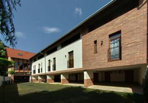 a large brick building with a yard in front of it at Maja Apartman in Gyula