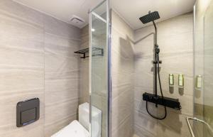 uma casa de banho com um chuveiro e um WC. em Ventimo Hotel & Residence Jeju em Jeju