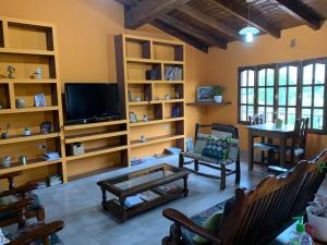 sala de estar con muebles y TV de pantalla plana. en Hostal CASA DE PIEDRA en Humahuaca