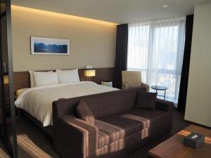 Postel nebo postele na pokoji v ubytování Ramada Encore by Wyndham Busan Haeundae