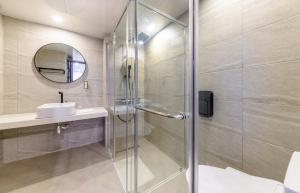a bathroom with a glass shower and a sink at Ventimo Hotel & Residence Jeju in Jeju