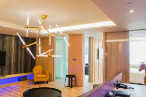 a living room with a yellow chair and a tv at FX Hotel Tainan in Tainan