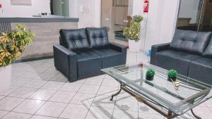 a living room with two chairs and a glass table at Nacional Park Hotel Lages in Lages