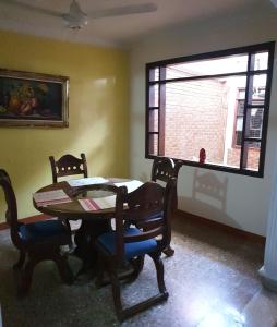 een eetkamer met een tafel en stoelen en een raam bij CasaHotel Barrancabermeja in Barrancabermeja