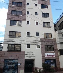 un edificio blanco alto con un letrero. en Brussels apartment, en La Paz