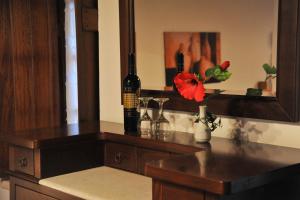 a counter with two bottles of wine and a flower on it at Pietra Suite in Monemvasia