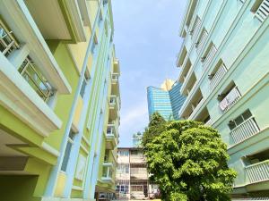un groupe de bâtiments avec un arbre entre eux dans l'établissement 14 Place Sukhumvit Suites, à Bangkok