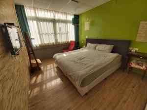 una camera da letto con un letto e una TV a schermo piatto di 稻禾民宿 a Ch'ieh-tung