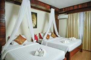 two beds in a room with white sheets at Angkor Pearl Hotel in Siem Reap